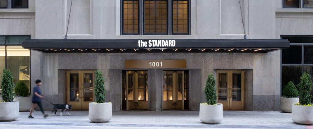 Pedestrian walking with a dog outside of The Standard Downtown Wilmington Luxury Apartments